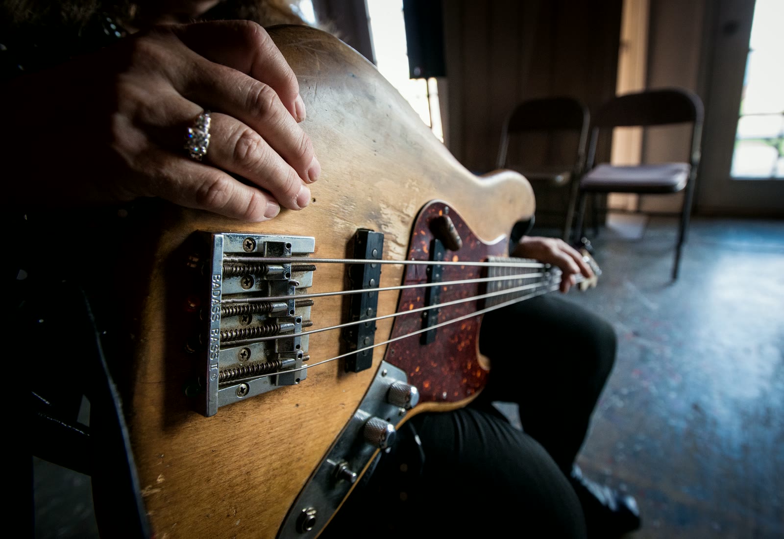 A road-worn four-string bass being played, the cover of The Geeky Nerds