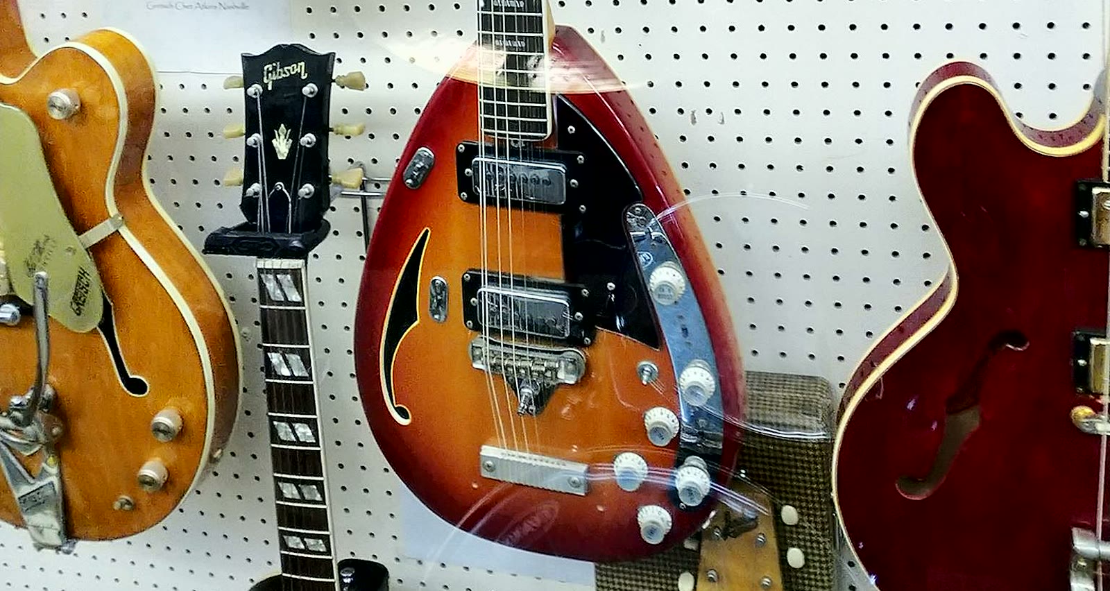 A wall of vintage guitars, the cover of The Gemini Academy