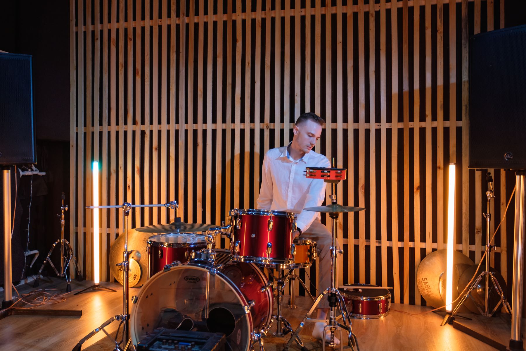 A drummer mid-hit on an acoustic kit under stage light, the cover of Rock & Roll